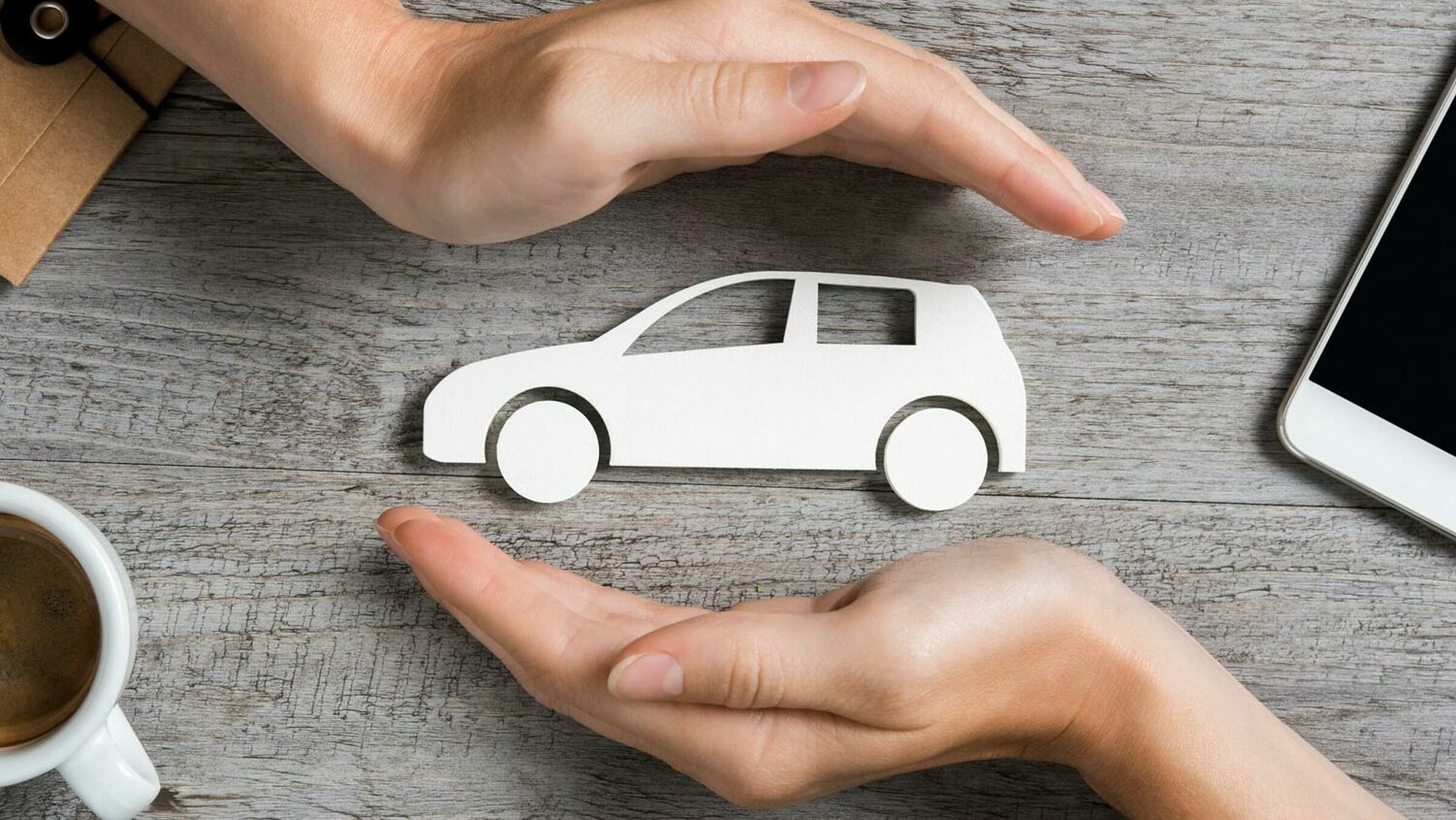 Bild zum Thema Versicherungen, Auto wird zwischen zwei Händen gehalten