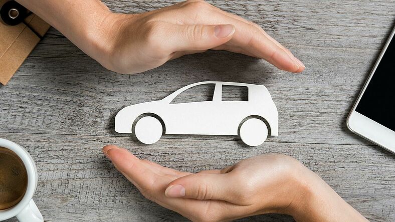 Bild zum Thema Versicherungen, Auto wird zwischen zwei Händen gehalten